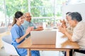 Asian senior man and woman enjoy to talk and fun with activity of nurse or doctor during teach with laptop on table in living room Royalty Free Stock Photo