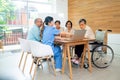 Asian senior man and woman enjoy to talk and fun with activity of nurse or doctor during teach with laptop on table in living room Royalty Free Stock Photo