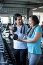 Asian senior man and woman exercise lifting dumbbell in fitness gym. elderly healthy lifestyle Royalty Free Stock Photo