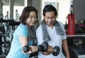 Asian senior man and woman exercise lifting dumbbell in fitness gym. elderly healthy lifestyle Royalty Free Stock Photo