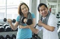 Asian senior man and woman exercise lifting dumbbell in fitness gym. elderly healthy lifestyle Royalty Free Stock Photo