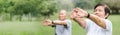 Asian Senior man and woman stretching hands and arms before exercise at park. Happy elderly couple enjoying workout at outdoor in Royalty Free Stock Photo