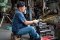 Asian senior mechanic use machine to lathe metal autoparts occur sparks and he work in garage workplace