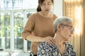 Asian senior mother have nerve pain,shoulder ache,neck pains,female caregiver or daughter massaging her shoulders, frustrated