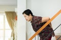 Asian senior older woman suffering from low-back lumbar pain while walking on stair at home
