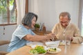Asian Senior olderly couple people eat food on dinner table in house. Loving Elderly mature smile, enjoy retirement life have