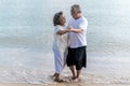 Asian senior retired couple dancing with relax happy smiling on sea beach, elder man and woman enjoying with retired vacation. Royalty Free Stock Photo
