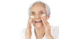 Asian senior woman apply anti-aging cream,nourish the skin to soft smooth,treat facial fine lines and wrinkled on the face,old Royalty Free Stock Photo