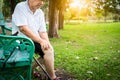 Asian senior woman arthritis,osteoarthritis,elderly people sitting,holding hand on the knee in park,feeling pain in the knee,