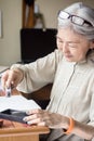 Asian senior woman artist using Suiteki and sudzuri Royalty Free Stock Photo