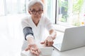 Asian senior woman checking blood pressure at home, elderly people check health using a blood pressure monitor, checking patients Royalty Free Stock Photo