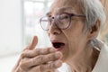 Asian senior woman checking breath with hand,old elderly doing a bad breath test,foul mouth from inside the tongue,teeth and gums Royalty Free Stock Photo