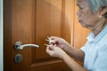 Asian senior woman is confused because she can not remember the key to opening the door of her bedroom,memory loss in elderly