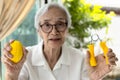 Asian senior woman doing hand,finger and wrist exercise with rubber ball and spring hand grip,stretch finger or squeeze with hand Royalty Free Stock Photo