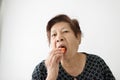 Asian senior woman eating ripe papaya sliced at home, lifestyle