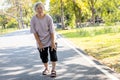 Asian senior woman is extremely tired while walking at park, body is weak feeling tired easily due to lack of energy and donÃ¢â¬â¢t