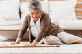 Asian senior woman falling down lying on floor at home alone. Elderly woman pain and hurt from osteoporosis sickness or heart
