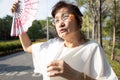 Asian senior woman fanning and sweat on face suffer from sunburn very hot in summer weather problem feel faint, tired female