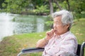 Asian senior woman feeling stressed,worried female bites finger nails in wheelchair outdoor park,elderly people with nervous Royalty Free Stock Photo