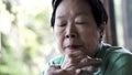 Asian senior woman with hand on face thinking, worry sad Royalty Free Stock Photo