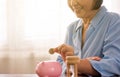 Asian senior woman hands putting coin to piggy bank for retirement,Saving money concept