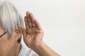 Asian senior woman having impaired hearing,deaf,ear disease,old elderly people trying to listening with hand over her ear,trouble
