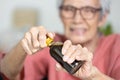 Asian senior woman hold a bottle of liquid drug,old elderly try to open the screw cap of bottle with difficulty,unscrew cap to