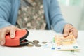 Asian senior woman holding counting coin money and Euro bnaknotes in purse. Poverty, saving problem in retirement Royalty Free Stock Photo