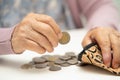 Asian senior woman holding counting coin money in purse. Poverty, saving problem in retirement Royalty Free Stock Photo