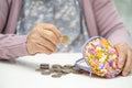 Asian senior woman holding counting coin money in purse. Poverty, saving problem in retirement Royalty Free Stock Photo