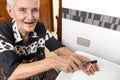 Asian senior woman holding a removable denture,old elderly brushing her denture plate with a toothbrush at the sink in bathroom, Royalty Free Stock Photo