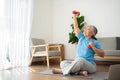 Asian senior woman lifting dumbbell for exercise and workout at home. Active mature woman doing stretching exercise in living room