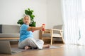 Asian senior woman lifting dumbbell for exercise and workout at home. Active mature woman doing stretching exercise in living room Royalty Free Stock Photo