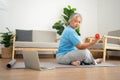 Asian senior woman lifting dumbbell for exercise and workout at home. Active mature woman doing stretching exercise in living room