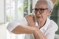 Asian senior woman massage her shoulder bone with hand,aching and tingling,old elderly patient with frozen shoulder,pain and