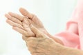 Asian senior woman is massaging her own hand,Elderly woman suffering from pain in hand,arthritis,beriberi