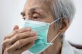 Asian senior woman in a medical mask,elderly patient covering nose and mouth with her hand while coughing or sneezing,prevent the Royalty Free Stock Photo