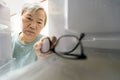 Asian senior woman with memory impairment symptoms,forget her glasses in the refrigerator or storing glasses in the fridge,female Royalty Free Stock Photo