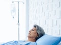 Asian senior woman patient grey hair sleeping on bed in modern white hospital room. Royalty Free Stock Photo