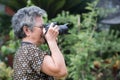 Asian senior woman shooting photo by digital camera Royalty Free Stock Photo