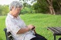 Asian senior woman sit asleep,snooze on chair,elderly female closed her eyes,resting in summer green nature,old people feeling
