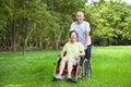 Asian senior woman sitting on a wheelchair with his husband