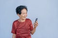 Asian senior woman smiles and video call isolated in grey background. Strong elderly grandmother feeling happy using mobile cell Royalty Free Stock Photo
