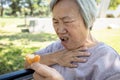 Asian senior woman suffers from choke and cough,clogged up food,elderly people choking during feeding,food might stuck in the