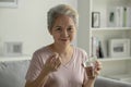 Asian senior woman taking medicine at home, smiling and looking at camera. Royalty Free Stock Photo