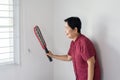 Asian senior woman using mosquito swatter at home,Female with mosquito electric net racket in bedroom Royalty Free Stock Photo