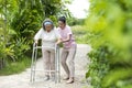 Asian senior woman walk with pian by walker, she living with Asian female physical therapist nurse take care Royalty Free Stock Photo