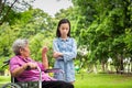 Asian senior woman in wheelchair angry,points her finger,admonishing little child girl in outdoor park,grandmother emotion Royalty Free Stock Photo