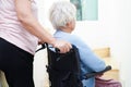 Asian senior woman on wheelchair with caregiver help support walking down the stairs prevent accident, slip and fall at home Royalty Free Stock Photo