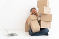 Asian Shopaholic man Shocked and sitting on the floor in the living room and Cardboard Box on top of him after The courier